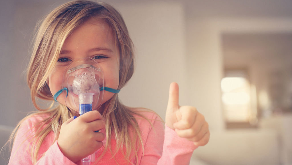 Hope for people with rare diseases Little girl using inhaler and showing OK.