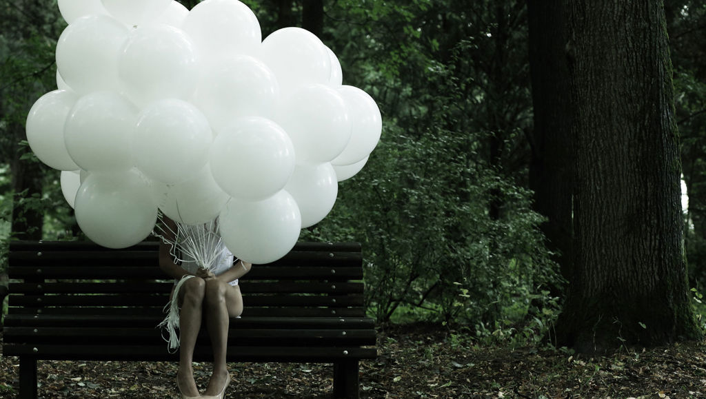 The data protection revolution explained Girl sat on bench with head obscured by bunch of white balloons
