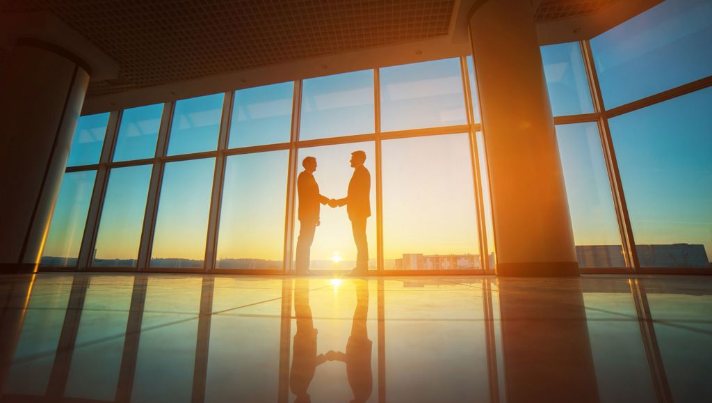Analysing the impact of digital tools on company law Two businessmen handshake in the office on the bright sun background